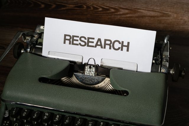 Typewriter with a page bearing the word "research."